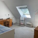 Bright private student bedroom with single bed, desk and skylight in a French host family home in Eybens.