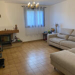 Bright family living room with comfortable sofa and fireplace in a host family home in Eybens near Grenoble.