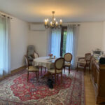 Elegant dining room with wooden furniture and air conditioning in a host family home in Eybens near Grenoble.