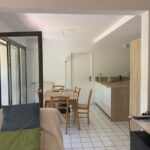 Bright open-plan living and dining area with modern kitchen in a French host family home.
