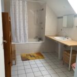 Spacious shared bathroom with bathtub and vanity in a French host family home.