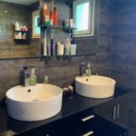 Modern shared bathroom with double vanity in a host family home near Grenoble.